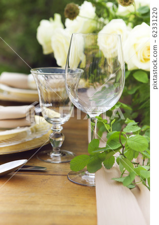 Candles and vase with white roses placed on round 62331220