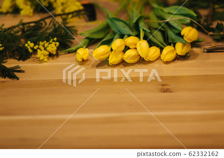 Working place of floristic. Yellow tulips lilac on wooden table 62332162