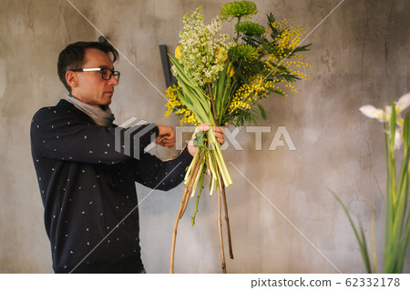 Flower shop make bouquet for a holiday. Family flower's business. Beautiful flower composition. Detail. Close up Flower shop make bouquet for a holiday. Family flower's business. Beautiful flower composition. Detail. Close up 62332178