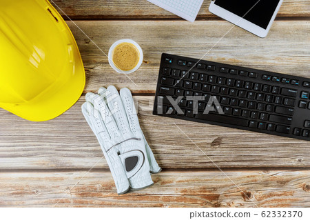 Yellow plastic safety helmet on construction 62332370