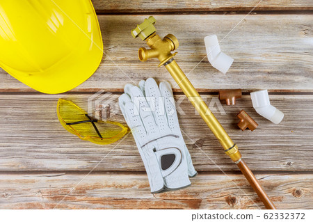 Protective hard work gloves on yellow hard-hat, Protective hard work gloves on yellow hard-hat, 62332372