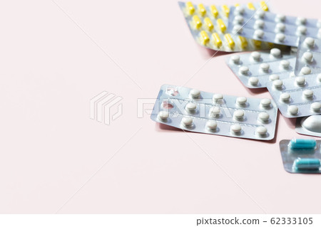 Heap of medical pills in white, blue and other colors. Pills in plastic package. Heap of medical pills in white, blue and other colors. Pills in plastic package. 62333105