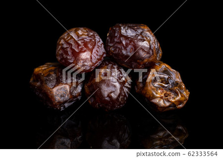 Dry brown date fruit isolated on black glass Dry brown date fruit isolated on black glass 62333564