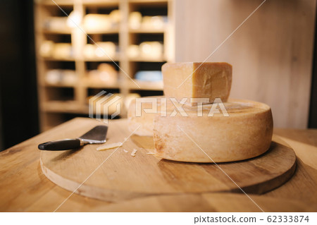 Cheese with knife of wooden board in cheese shop Cheese with knife of wooden board in cheese shop 62333874