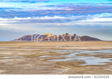 Vast sandy shore of a lake under bright blue sky 62334105