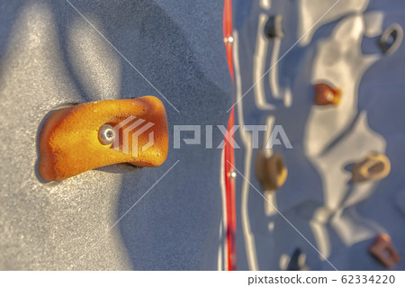 Bright orange foothold or handhold of a climbing Bright orange foothold or handhold of a climbing 62334220