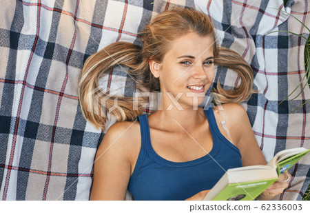 young, beautiful girl holding an open book, read background summer green park young, beautiful girl holding an open book, read background summer green park 62336003