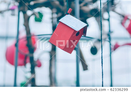 Red wooden birdhouse hanging on the thread Red wooden birdhouse hanging on the thread 62336299
