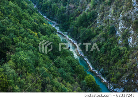 Mountain gorge with a river below. Green mountains. Canyon of mountain river on steep slopes 62337245