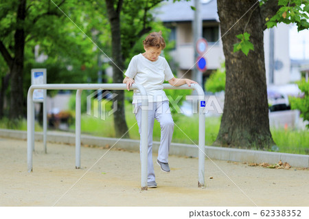Elderly woman exercising with fitness equipment Elderly woman exercising with fitness equipment 62338352
