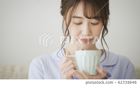 Woman with mug in pajamas Woman with mug in pajamas 62338646