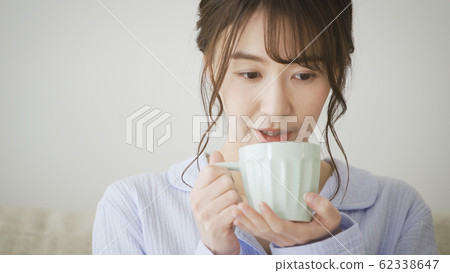 Woman with mug in pajamas 62338647