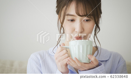 Woman with mug in pajamas 62338648