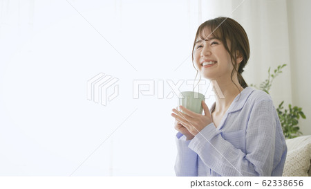Woman with mug in pajamas 62338656