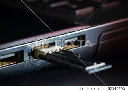 Flash drive in USB port of computer notebook in darkness. Concept of technological advances in computer data recording systems. Flash drive in USB port of computer notebook in darkness. Concept of technological advances in computer data recording systems. 62340290