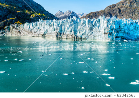 Glacier Bay Alaska cruise vacation travel. Global warming and climate change concept with melting ice. Cruising boat towards landscape of Johns Hopkins Glacier and Mount Fairweather Range mountains 62342563