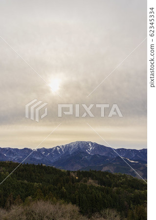 Magome / Vertical photo of snow-capped mountains and dim clouds transparent to the sun Magome / Vertical photo of snow-capped mountains and dim clouds transparent to the sun 62345334