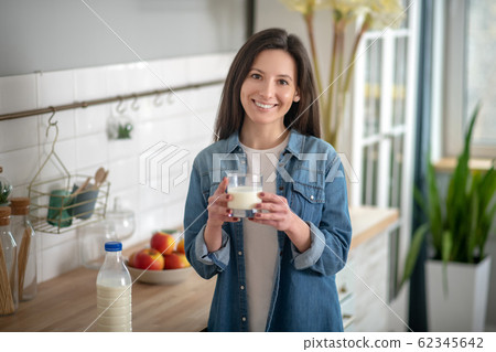 Young woman holding a glass of joghurt 62345642
