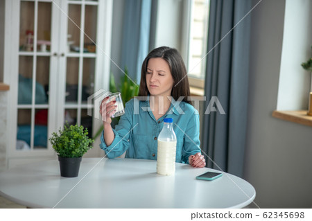 Woman drinking milk despite not likinng dairy products 62345698