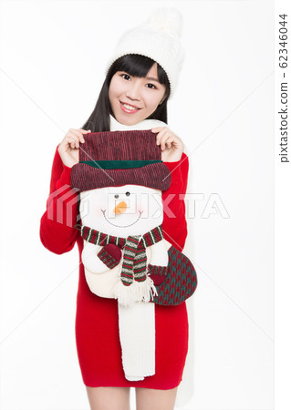 Portrait of young woman holding a large christmas Portrait of young woman holding a large christmas 62346044