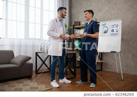 Two doctors talking during changeover and looking positive Two doctors talking during changeover and looking positive 62346269