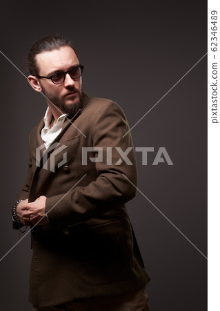 Serious male in jacket on brown background 62346489