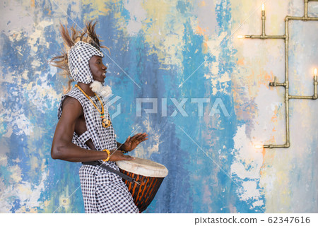 African artist in traditional clothes playing djembe drum African artist in traditional clothes playing djembe drum 62347616