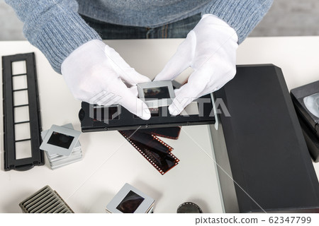man photographer looking at film slide man photographer looking at film slide 62347799
