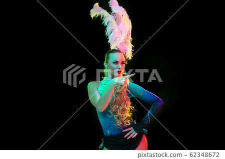 Beautiful young woman in carnival and masquerade costume in colorful neon lights on black background Beautiful young woman in carnival and masquerade costume in colorful neon lights on black background 62348672
