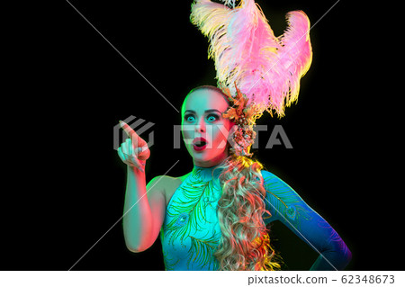 Beautiful young woman in carnival and masquerade costume in colorful neon lights on black background 62348673