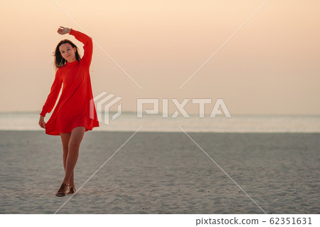 Adorable happy little girl on white beach at sunset. 62351631