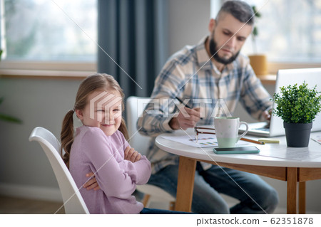 Little daughter and young dad sitting at the table at home. 62351878