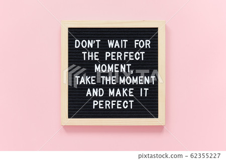 Don't wait for the perfect moment, take the moment and make it perfect. Motivational quote on black letter board frame on pink background. Concept inspirational quote of the day 62355227