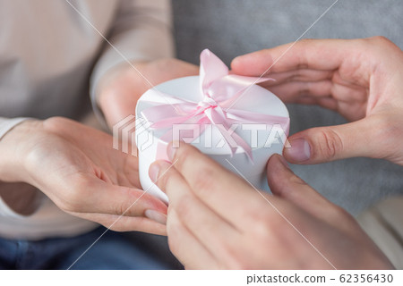 舉手介紹禮物的年輕男女 舉手介紹禮物的年輕男女 62356430