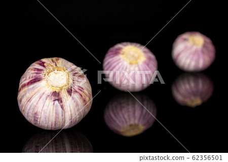 Single clove garlic isolated on black glass 62356501