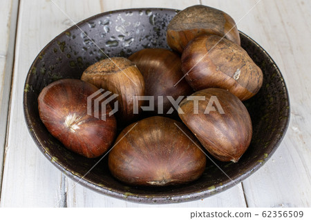 Brown edible chestnut on grey wood Brown edible chestnut on grey wood 62356509