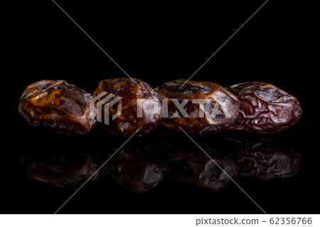 Dry brown date fruit isolated on black glass Dry brown date fruit isolated on black glass 62356766