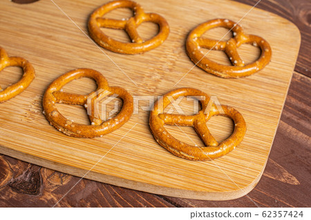 Salty brown pretzel on brown wood Salty brown pretzel on brown wood 62357424
