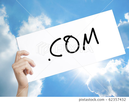 .COM Sign on white paper. Man Hand Holding Paper with text. Isolated on sky background.  Business concept. Stock Photo 62357432