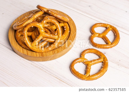 Salty brown pretzel on grey wood Salty brown pretzel on grey wood 62357585