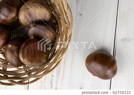 Brown edible chestnut on grey wood Brown edible chestnut on grey wood 62358122
