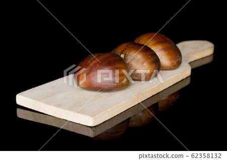 Brown edible chestnut isolated on black glass 62358132
