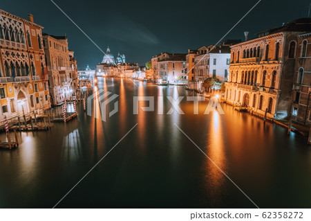 Venice, Italy. Night scene at Grand Canal with reflected light at water surface. Majestic Basilica di Santa Maria della Salute in background 62358272