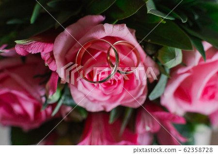 New wedding rings next to the bride's bouquet. New wedding rings next to the bride's bouquet. 62358728