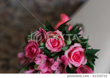 New wedding rings next to the bride's bouquet. New wedding rings next to the bride's bouquet. 62358732