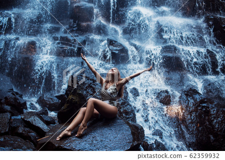 Beautiful sexy girl under Kanto Lampo waterfall in Indonesia. Beautiful sexy girl under Kanto Lampo waterfall in Indonesia. 62359932