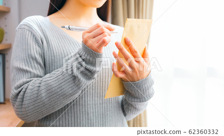 Woman filling in envelope 16: 9 Woman filling in envelope 16: 9 62360332