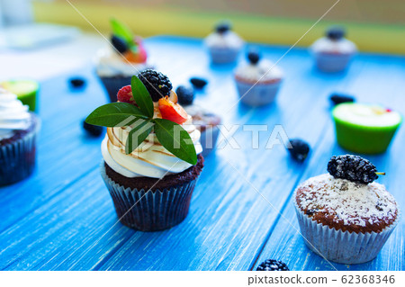 Freshly baked sweet muffins on a blue background. 62368346