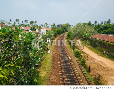 Railway track near residential buildings. A Railway track near residential buildings. A 62368837