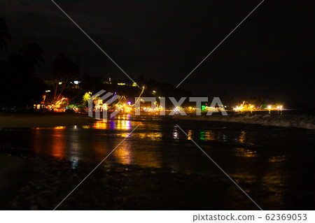 Oceanfront restaurant with lights and tables on a Oceanfront restaurant with lights and tables on a 62369053